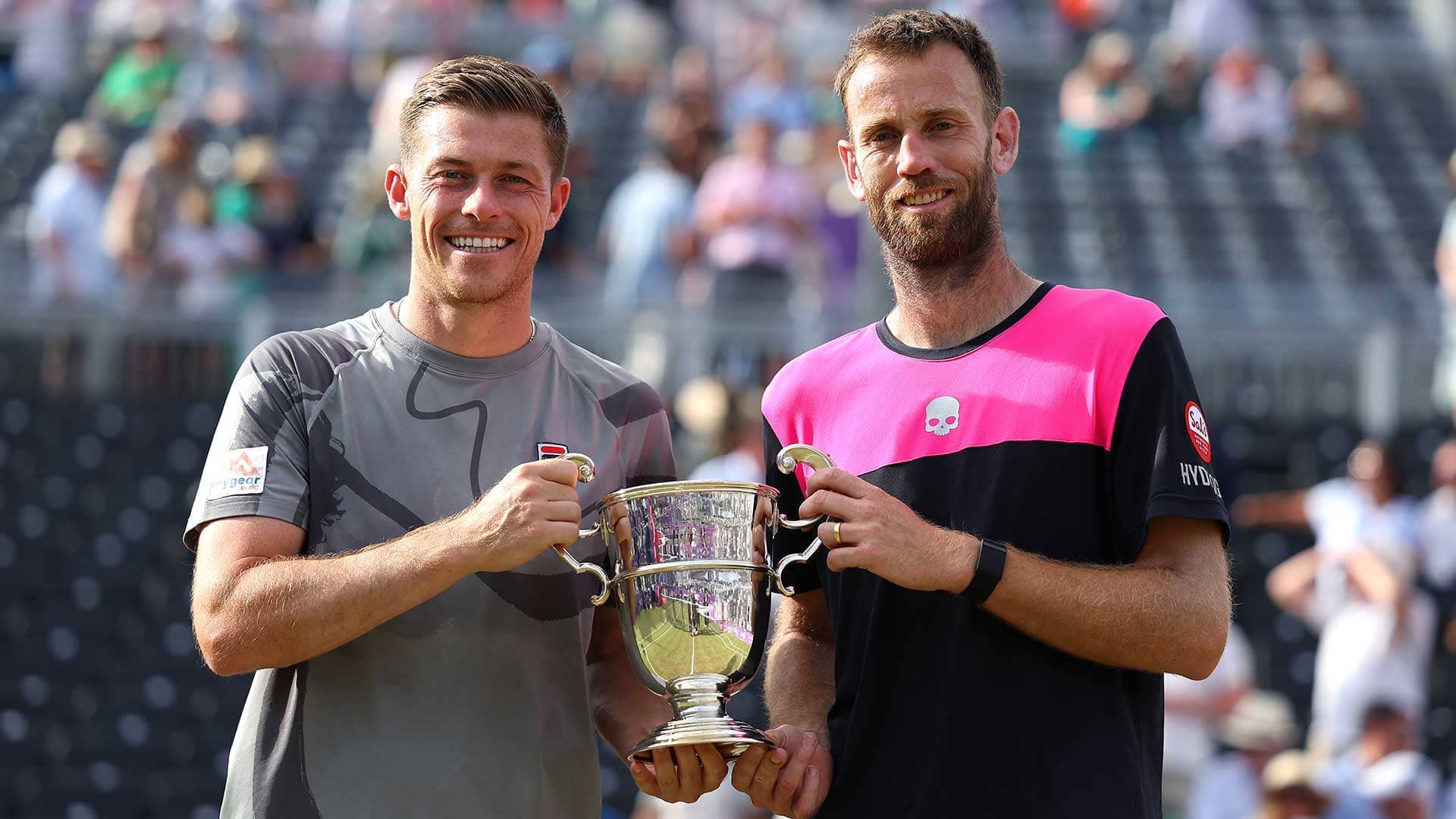 Neal Skupski and Michael Venus lift the trophy in London.