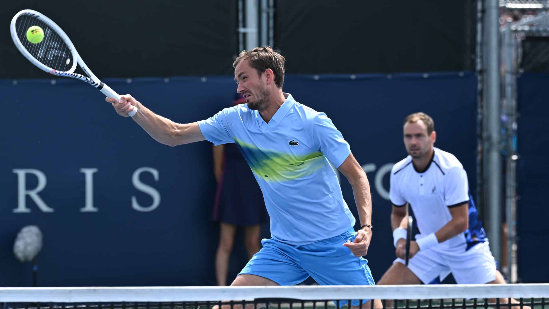 <a href='https://www.atptour.com/en/players/daniil-medvedev/mm58/overview'>Daniil Medvedev</a> lunges for a volley as <a href='https://www.atptour.com/en/players/roman-safiullin/sx50/overview'>Roman Safiullin</a> looks on during their Tuesday victory in Montreal.